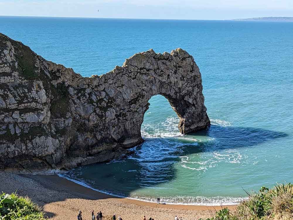 Durdle Door, Dorset, UK Blue sky and seat and the impressive cliff archway at Durdle Door, Dorset, UK