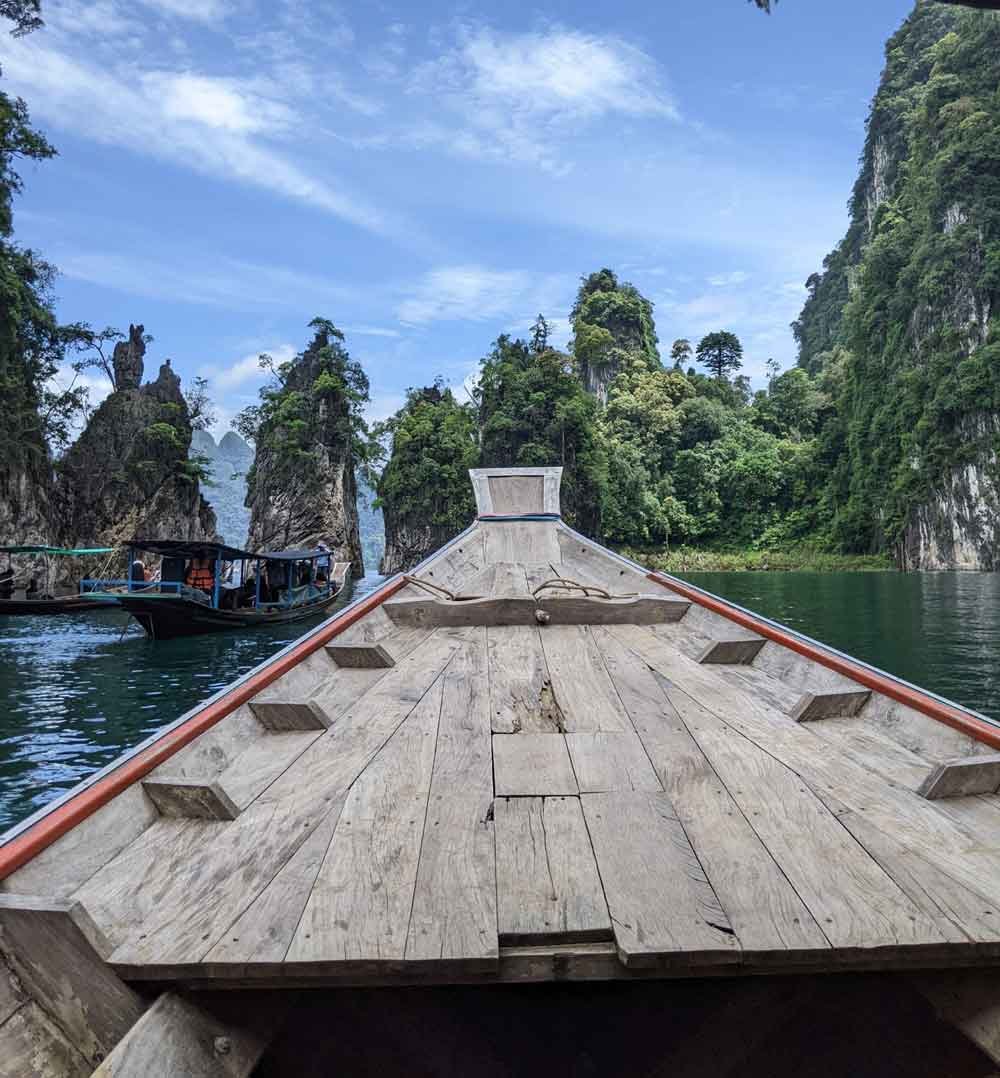 View of limestone cliffs from bow of boat, Cheow Lan Lake, Thailand